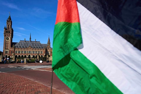A Palestinian flag flies outside the International Court of Justice, rear, which opened hearings into a United Nations request for an advisory opinion on Israel's obligations to allow humanitarian assistance in Gaza and the West Bank, in The Hague, Netherlands, April 28, 2025.