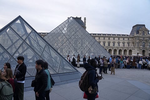 Visitors queue to enter the Louvre museum three days after historic jewels were stolen in a daring daylight heist, Wednesday, Oct. 22, 2025 in Paris.