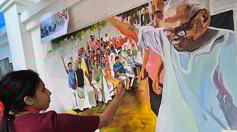Kavya S Nath near the painting she drew of VS Achuthanandan.