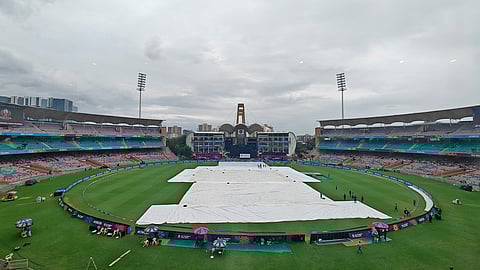 Ground staff cover the pitch as it rains prior to the ICC Women's Cricket World Cup match between India and Bangladesh at DY Patil Stadium in Navi Mumbai, Maharashtra, Sunday, Oct. 26, 2025.
