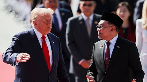 U.S. President Donald Trump talks with Malaysia Prime Minister Anwar Ibrahim as he arrives at Kuala Lumpur International Airport to attend the 47th Association of Southeast Asian Nations (ASEAN) summit in Kuala Lumpur, Malaysia, Sunday, Oct. 26, 2025.