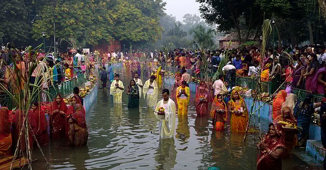 Woman performs Chhath Puja rituals while standing at Sanjay lake in New Delhi on Wednesday.