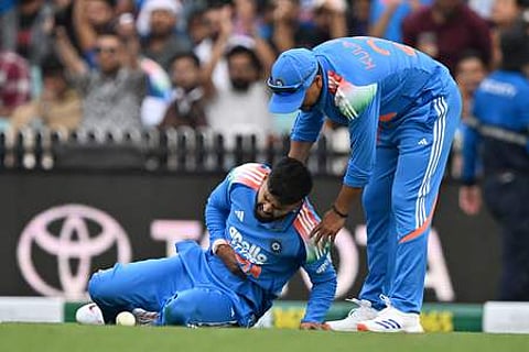 India's Shreyas Iyer (L) reacts in pain after falling on the ground while taking a catch to dismiss Australia's Alex Carey during the third one-day
