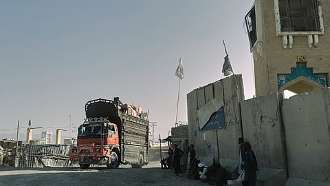 People wait near the closed gate at the Spin Boldak border crossing with Pakistan, after the border was shut for nearly two weeks following clashes between Afghan and Pakistani forces, in Kandahar province, Afghanistan, Thursday, Oct. 23, 2025.