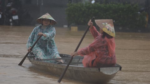 People paddle a boat on a flooded street in Hue, Vietnam, Tuesday, Oct. 28, 2025.