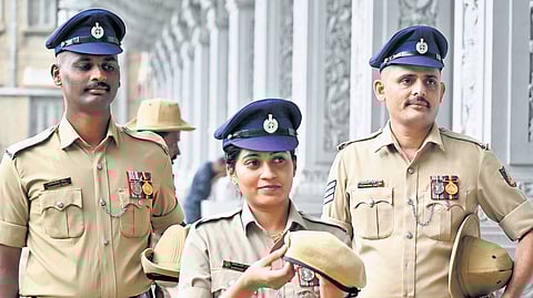 Police personnel wearing the new navy blue peak caps hold the old slouch hats
in Vidhana Soudha in Bengaluru on Tuesday