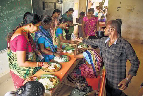 People evacuated from their homes to a relief camp in Uppada village of Kakinada district having lunch on Tuesday