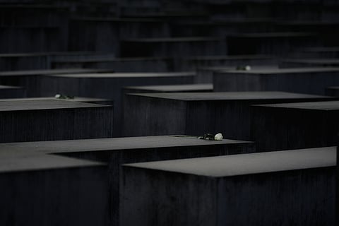 White roses lay on concrete slabs of the Holocaust Memorial in Berlin, Germany, Tuesday, Oct. 28, 2025.