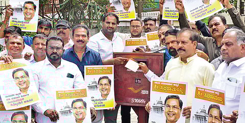 Members of various AHINDA organisations launch a postcard campaign urging Rahul Gandhi to publicly affirm that CM Siddaramaiah will complete his full five-year term, in Mysuru on Wednesday.