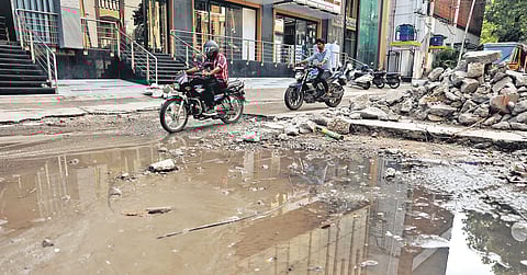 Motorists negotiate a damaged road in Pragathi Nagar, Yousufguda, which falls under the Jubilee Hills Assembly constituency in Hyderabad.