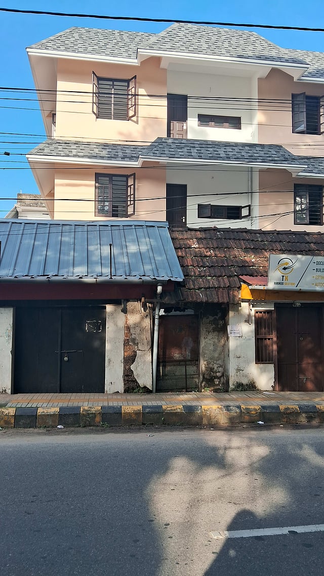 A commercial building with one half asbestos roofing, one half traditional tiles