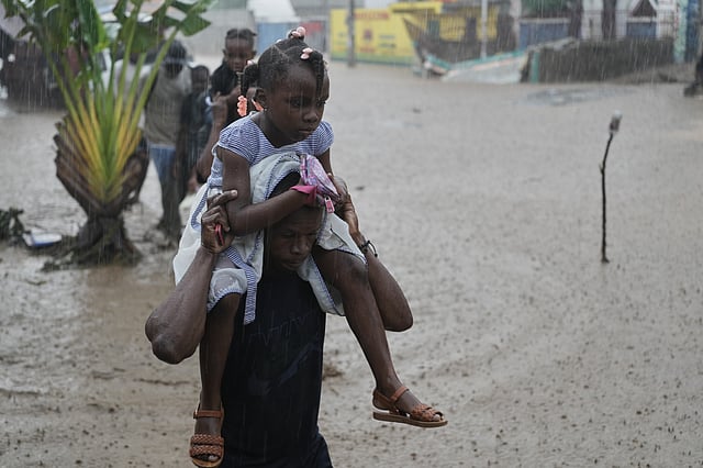Residents wade through a flooded street in the aftermath of Hurricane Melissa in Petit-Goave, Haiti, Thursday, Oct. 30, 2025.