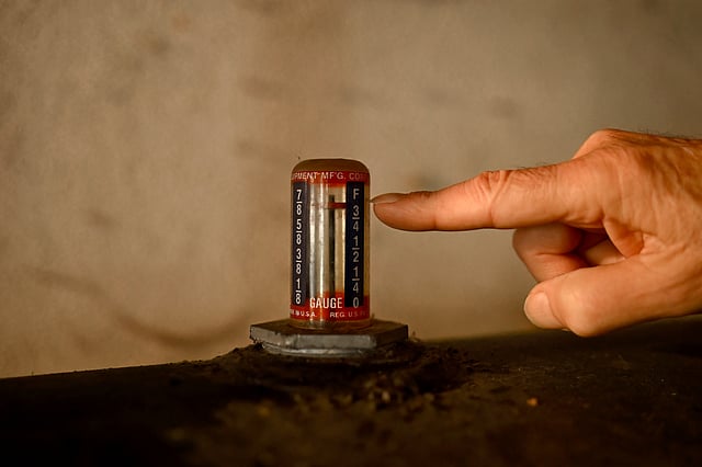 Mark Bain, who is part of the Low Income Home Energy Assistance Program, checks the level on his oil at home in hopes that he will have enough oil to outlast the shutdown, in Bloomfield, Conn., Monday, Oct. 27, 2025.