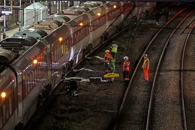 Emergency personnel inspect a train at the Huntingdon, England, train station in Cambridgeshire after people were stabbed Saturday, Nov. 1, 2025.