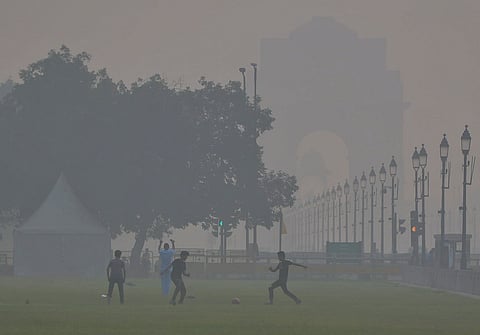 Children play football near India Gate as smog engulfs the area, with the Air Quality Index (AQI) remaining in the 'very poor' category, in New Delhi, Sunday, Nov. 2, 2025.