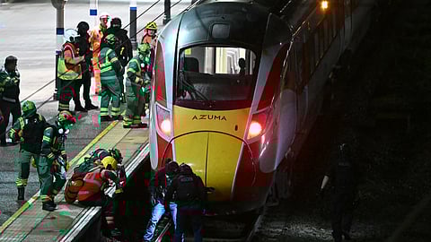 Emergency personnel inspect a train at the Huntingdon, England, train station in Cambridgeshire after people were stabbed Saturday, Nov. 1, 2025