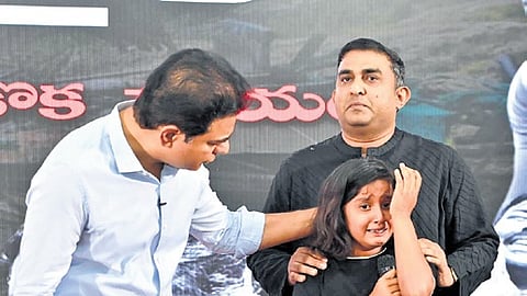 BRS working president KT Rama Rao consoles a girl during a photo exhibition on HYDRAA demolitions at Telangana Bhavan in Hyderabad on Sunday