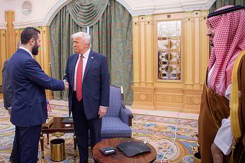 In this photo provided by the Saudi Royal Palace, Syria's interim President Ahmad al-Sharaa, left, shakes hands with U.S. President Donald Trump in Riyadh, Saudi Arabia, Wednesday, May 14, 2025. At foreground right is Saudi Crown Prince Mohammed bin Salman.