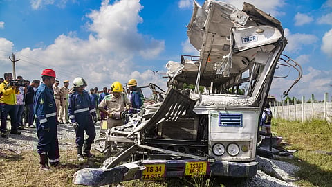Police and firefighters look at the wrecked remains of a public transport bus after a head-on collision with a tipper lorry carrying gravel, in Rangareddy district, Telangana, Monday, Nov. 3, 2025.