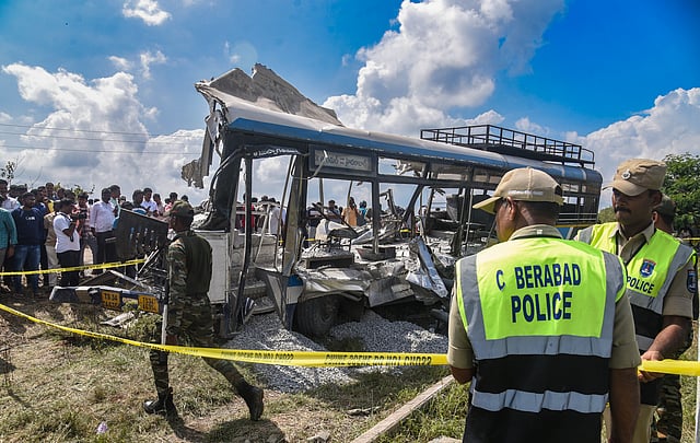 Police cordon off the site after a tipper lorry carrying gravel collided head-on with a public transport bus, in Rangareddy district, Telangana, Monday, Nov. 3, 2025.