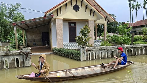 Local residents paddle a boat through a flooded street in Hue, Vietnam, Friday, Oct. 31, 2025.