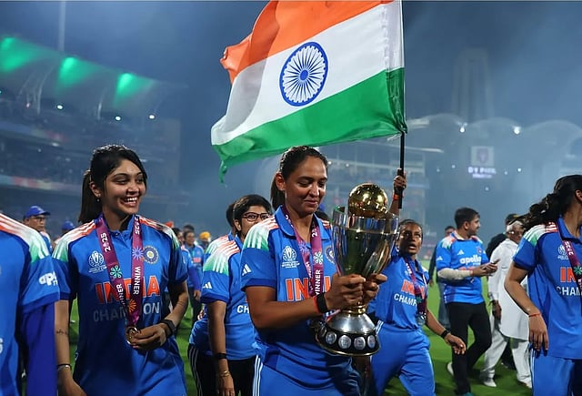 Harleen Deol (L) and Harmanpreet Kaur (C) walking with the trophy