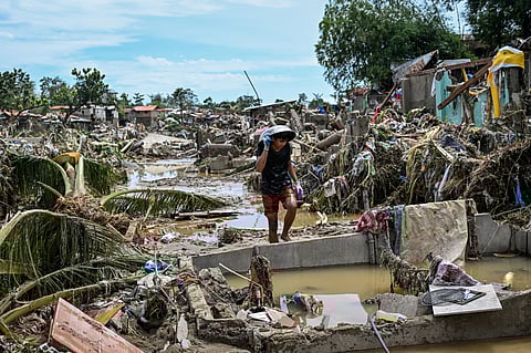A resident walks along damaged houses in the aftermath of Typhoon Kalmaegi in Talisay, in the province of Cebu on November 5, 2025.