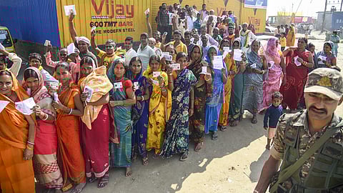 Voters wait in a queue to cast votes at a polling station in Bihar.