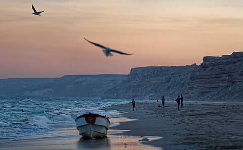 FILE - Fishermen stand on the Indian Ocean beach at dusk in the former pirate village of Eyl, in Somalia's semiautonomous northeastern state of Puntland, Somalia, Monday March 6, 2017.