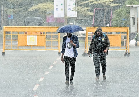 People walk in the rain at Nandambakkam on Thursday =