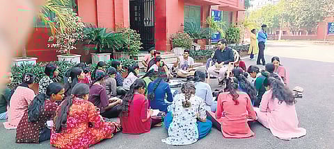 Students of Plus III 2nd year Odia dept studying in the open in front of the V-C’s office as a mark of protest, on Thursday.