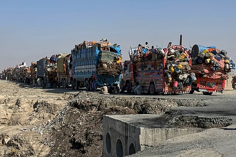 Afghan refugees sit beside trucks loaded with their belongings as they wait their turn to leave for their homeland through a border crossing point which partially opens following Oct.19 ceasefire, on the outskirts of Chaman, a border town on the Pakistan Afghan border, Wednesday, Oct. 29, 2025.