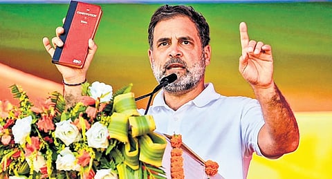 Rahul Gandhi holds a copy of the Consitution of India at a rally in Kishanganj.