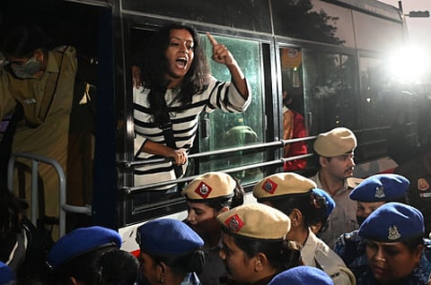 Police personnel detain demonstrators during a protest demanding the government to take action to reduce air pollution near India Gate in New Delhi, Nov 23, 2025.