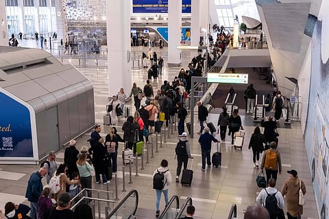 People wait in line at a Transportation Security Administration (TSA) security checkpoint at LaGuardia Airport in the Queens borough of New York, Sunday, Nov 9, 2025.