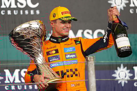McLaren driver Lando Norris of Britain celebrates on the podium his first place in the Brazilian Formula One Grand Prix at the Interlagos race track in Sao Paulo, Sunday, Nov. 9, 2025.