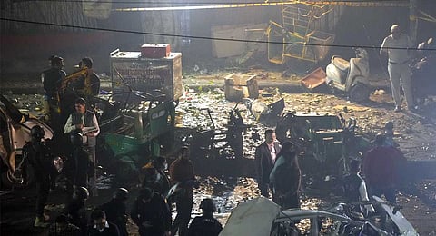 Officers from various security agencies investigate the spot after a blast occurred in a parked car near Red Fort, leaving multiple vehicles in flames, in New Delhi, Monday, Nov. 10, 2025. At least nine people were killed and 24 others suffered injuries in the incident.