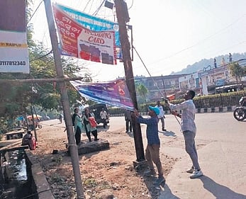 Unauthorised banners being removed from along a road in Sambalpur.