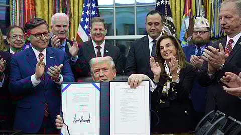 President Donald Trump displays the signed funding bill to reopen the government, in the Oval Office of the White House, Wednesday, Nov. 12, 2025, in Washington
