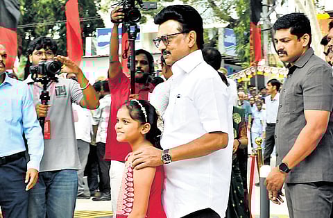 Chief Minister MK Stalin posing for camera with a girl at the inauguration venue in Kolathur on Friday.