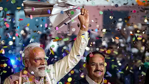 Prime Minister Narendra Modi waves a 'gamcha' as he arrives during the celebration of NDA's victory in the Bihar Assembly elections, at BJP headquarters, in New Delhi, Friday, Nov. 14, 2025.