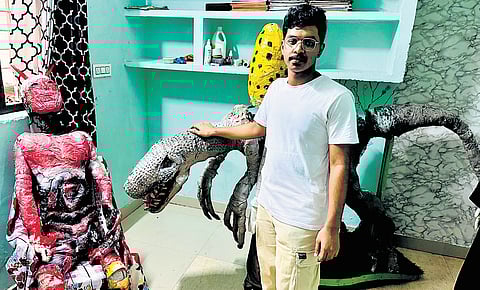 Ajsal beside his models created from discarded materials