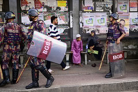 Security personnel walk past a bus stop as ousted Prime Minister Sheikh Hasina and her former ruling Awami League party called for a nationwide "lockdown" in protest against her trial, in Dhaka, Bangladesh, Thursday, Nov. 13, 2025.