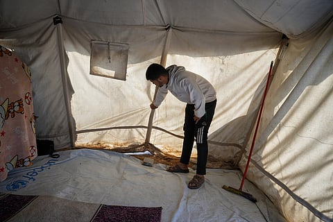 Muhannad Abu Muharib, 27, reinforces his tent after it was damaged by the storm at a temporary camp on the beach in Deir al-Balah, in the central Gaza Strip, Saturday, Nov. 15, 2025.