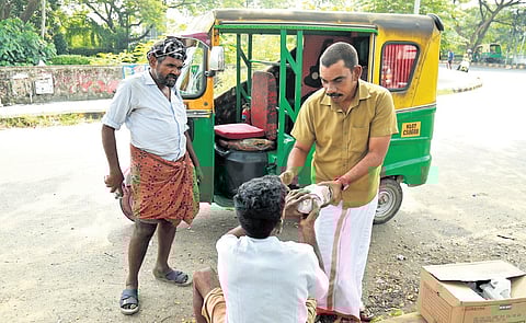 Anaz Panavally, an autorickshaw driver, distributing food packets to the poor and homeless in Kochi.