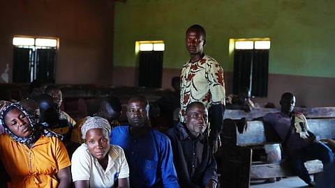 The Rev. Micah Bulus, right, standing, a pastor who was kidnapped along with others from a church service in November 2024, speaks with church members in Kaduna, northwestern Nigeria, Nov. 6, 2025.