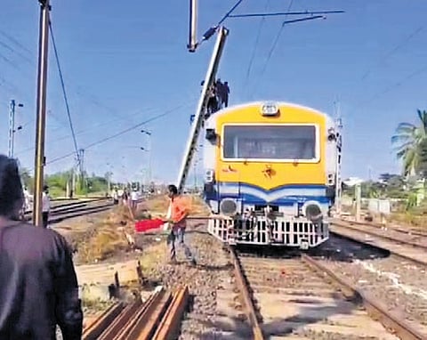 Technicians working to clear the obstruction of an electric pole to restore train operations near Pendurthi railway station in Visakhapatnam district