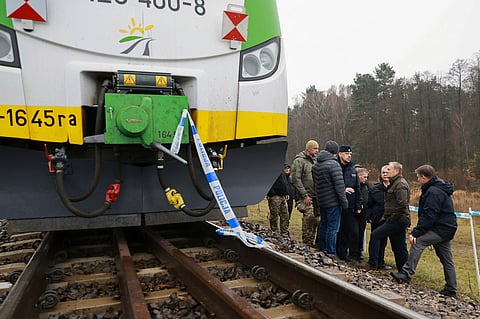 Prime Minister Donald Tusk, second right, visits site of the rail line Mika, that was damaged by sabotage, near Deblin, Poland, Monday, Nov. 17, 2025.