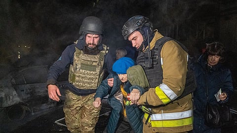 Rescuers evacuate an elderly woman after a residential building was hit following Russia's missile attack in Kharkiv, Ukraine Wednesday, Nov. 19, 2025.