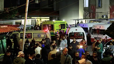 People gathering next of ambulances outside a hospital where they brought the victims of the Israeli strike that hit the Ein el-Hilweh refugee camp in the southern port city of Sidon, Lebanon, Tuesday, Nov. 18, 2025.